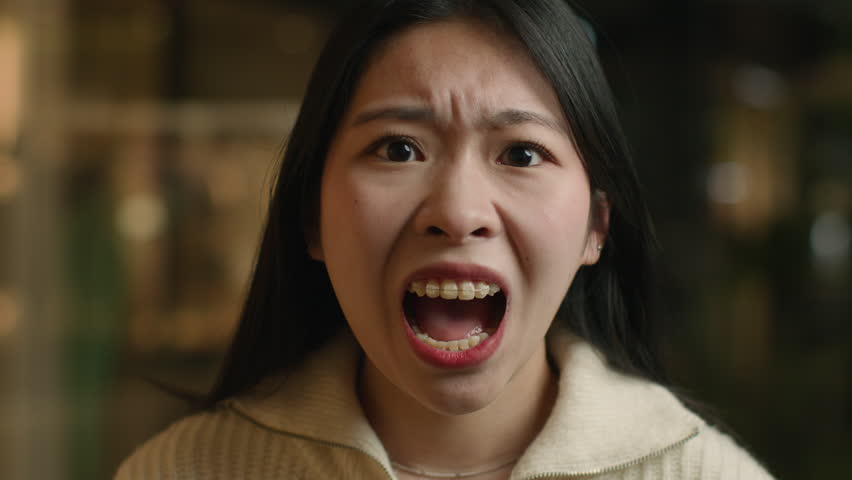 Portrait angry crazy Asian chinese woman shout open mouth shouting irritated emotion screaming aggressive japanese korean girl female scream yelling furious mad client customer feel anger stress rage | Shutterstock HD Video #1102243383