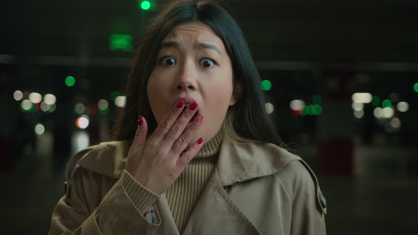Afraid girl Asian chinese japanese woman shocked bad news frightened korean lady in car parking underground open mouth feel horror terrified facial emotion looking at camera panic shock fear stress