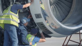 Aircraft mechanics and engineers diagnose and repairing jet engine through open hatch. Airplane turbine repair - Powered by Shutterstock - Get 15% off with code: PIKWIZARD15