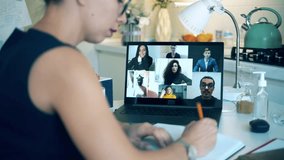 Female worker talks to her colleagues via laptop during coronavirus pandemic. Videocall , video conference, online meeting, working remotely concept. - Powered by Shutterstock - Get 15% off with code: PIKWIZARD15