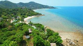White sand beaches that are fringed by swaying palm trees and clear, turquoise waters. The beaches are typically surrounded by lush green jungle, which adds to their natural beauty. Thailand. Drone
