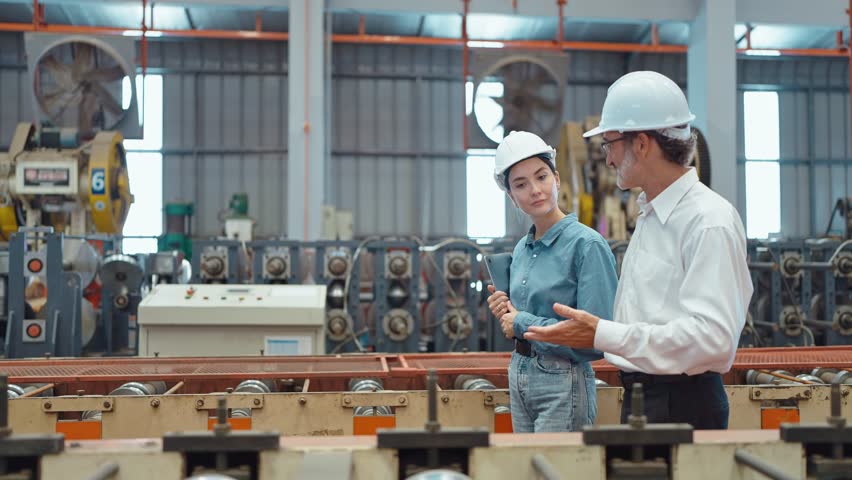 Workers partners holding tablet walking at manufacturing factory manager leader industrial specialist discussing project work with woman engineer warehouse. Teamwork concept Royalty-Free Stock Footage #1102254265
