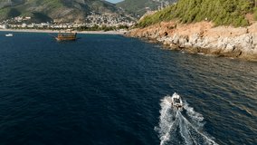 Aerial drone tracking top down video of yacht cruising in deep blue open ocean sea
