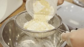 Close up video of chef sifting flour and cacao through sieve for preparing macaroons dough
