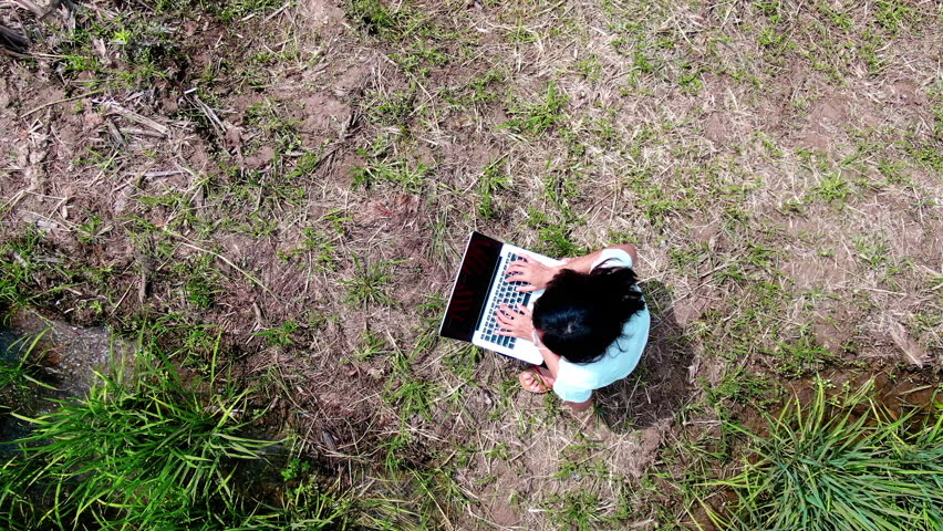 Earth Zoom out from paddy field with Asian woman using laptop to see the Earth from space. The animation continues by zoom out through clouds and atmosphere into space. Images from NASA.  Royalty-Free Stock Footage #1102265137