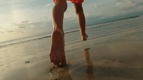 Back view of barefoot kids runs on wet sand beach in close up - Powered by Shutterstock - Get 15% off with code: PIKWIZARD15