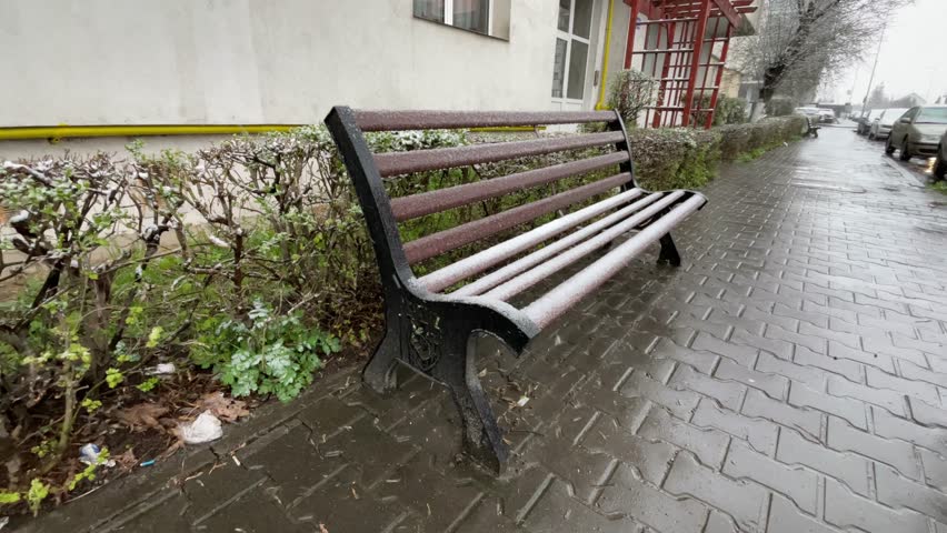 Bench in the street while snowing