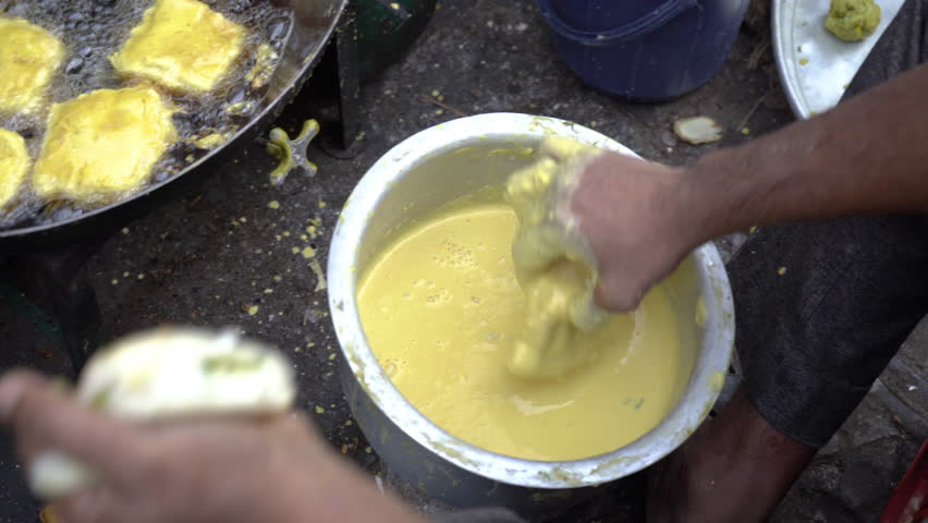 Frying vada in a big oil pan, Mumbai city, India