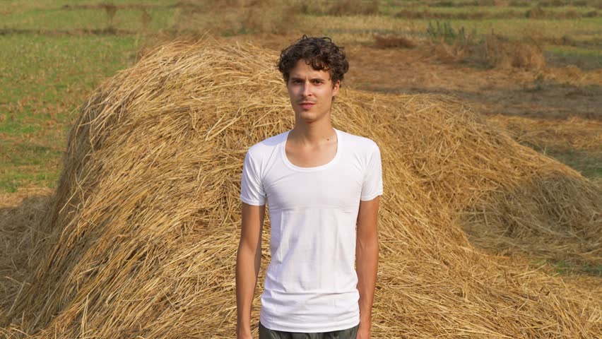 Man in a white shirt falling in a haystack