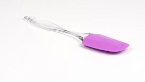 Pink rubber spatula, kitchen utensil. Isolated on white background. Side view. Loop motion. Rotation 360. 4K UHD video footage 3840X2160.