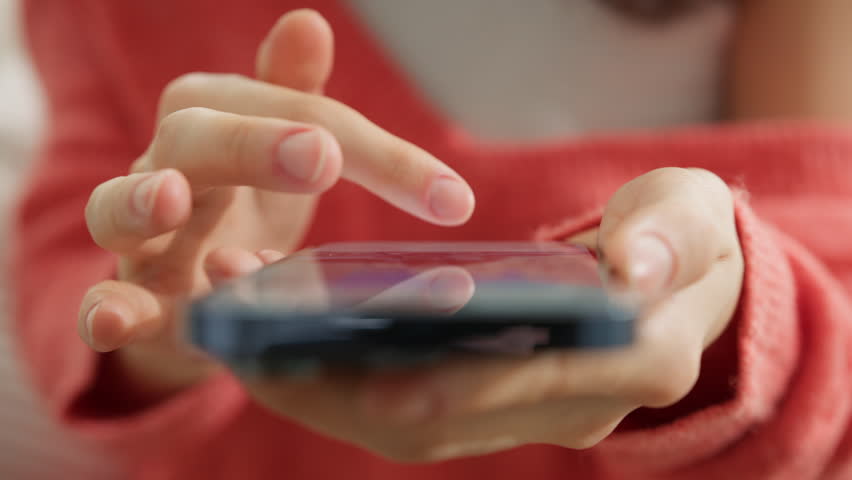 Cinematic close up shot of finger of woman touching screen of modern smartphone. Girl scrolling pages in mobile app on cell phone device. Browsing movie video on internet library to watch film online Royalty-Free Stock Footage #1102282289