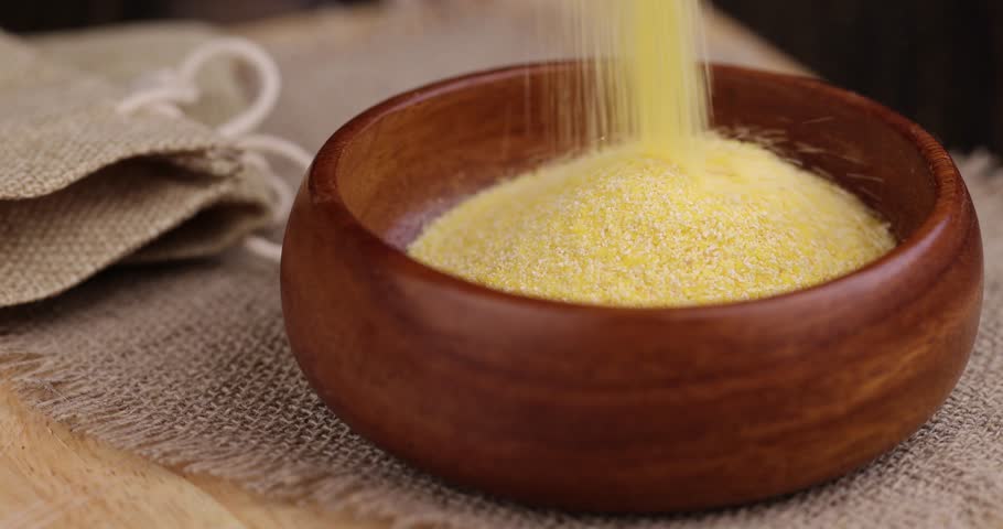 pour in Round wooden bowl with dry corn flour for cooking porridge, high-quality corn flour from corn grains in a bowl for a studio Royalty-Free Stock Footage #1102283571