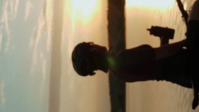 Portrait of sportive woman drinking water at sunset. Vertical video. Female cyclist drinks water from bottle after riding bicycle in sunset lights. Cycling and triathlon concept. Active lifestyle - Powered by Shutterstock - Get 15% off with code: PIKWIZARD15