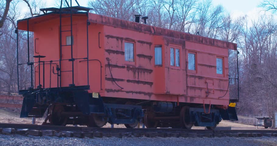 Static shot of an abandoned train carriage on the tracks in the countryside
