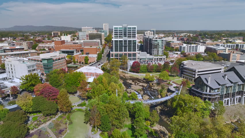 Aerial view of Reedy River Waterfalls in downtown of Greenville city in South Carolina. Falls Park riverwalk at Liberty bridge. American travel destination.