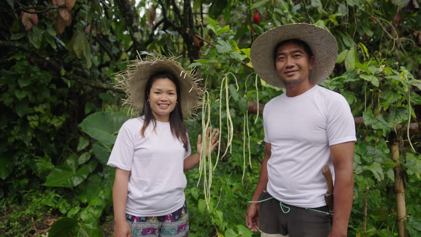 Portrait of happy asian couple in vegetable garden, proud smallholder, asia