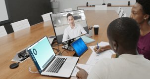 Diverse businesswomen in office using computer with video call and ai messaging on screens. Business, office, communication and digital interface technology.