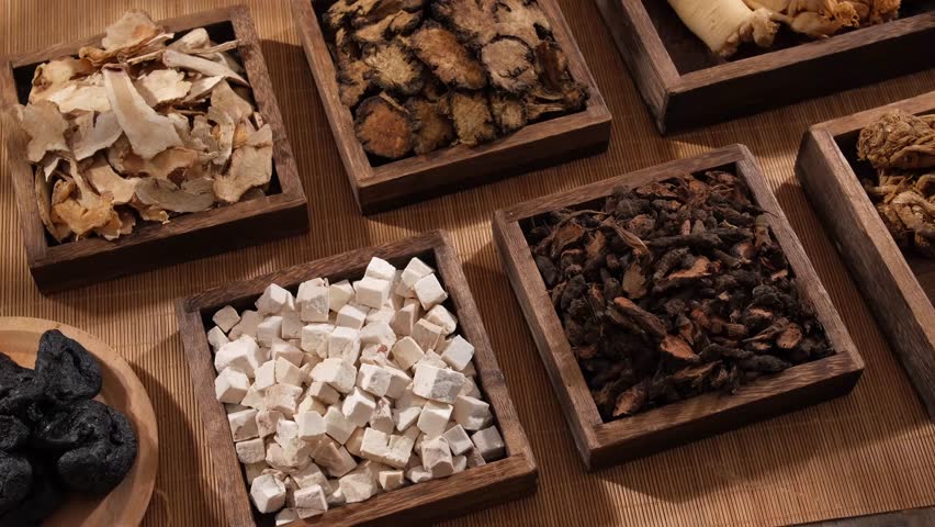 A closeup view of many types of herbs, placed on wooden tray with square and rectangle shape. Traditional chinese medicine concept Royalty-Free Stock Footage #1102292643