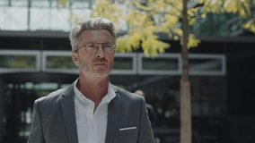Middle aged man in suit running to his male boss with clipboard in hands. Senior businessman signing some urgent papers near office building. Busy business people - Powered by Shutterstock - Get 15% off with code: PIKWIZARD15