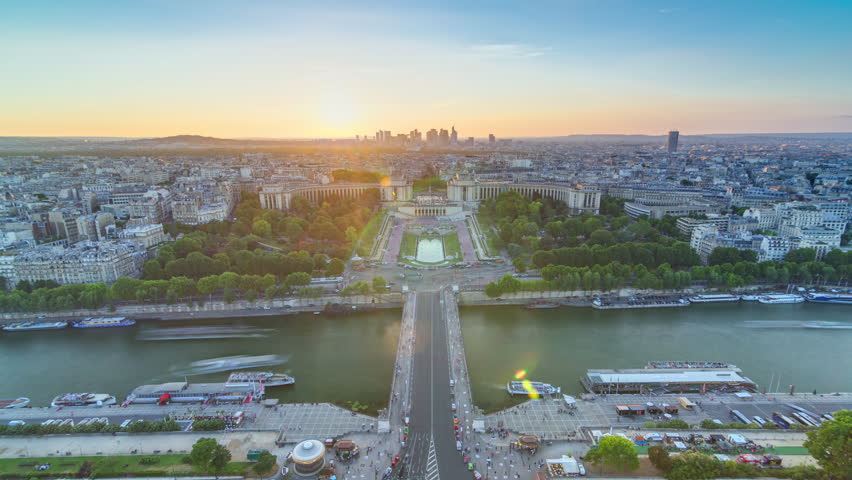 Sunset over Trocadero timelapse with the Palais de Chaillot seen from the Eiffel Tower viewpoint in Paris, France. Top view from observation deck with river Seine and ship crossing it at summer day