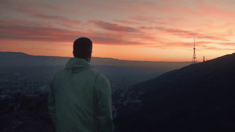 The guy after morning run standing and calm down with a great sunrise view .  Vídeo Stock