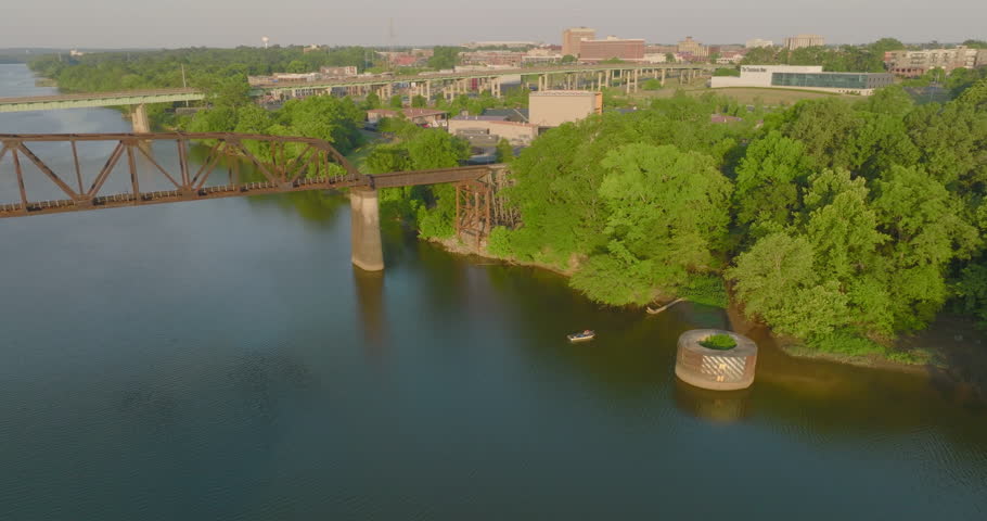 Aerial Descending Shot Of Boat On River Below Black Warrior Railroad Bridge In Residential City - Tuscaloosa, Alabama