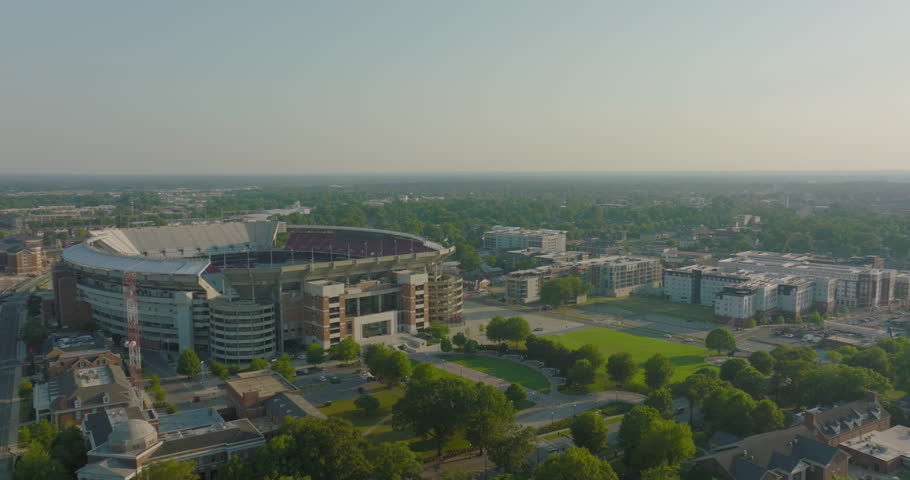 Aerial Forward Panning Shot Of Bryant-Denny Stadium In City Against Sky On Sunny Day - Tuscaloosa, Alabama