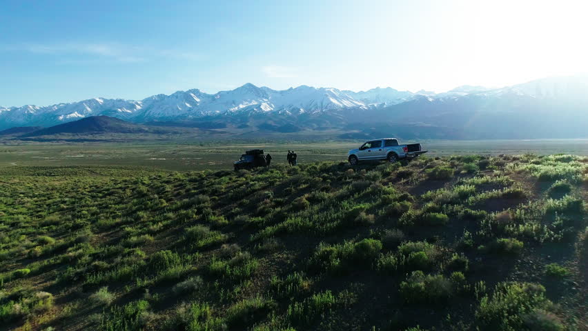 Aerial Backward Shot Of Scenic Green Landscape With Mountain Range In Background Against Sky - Big Pine, California