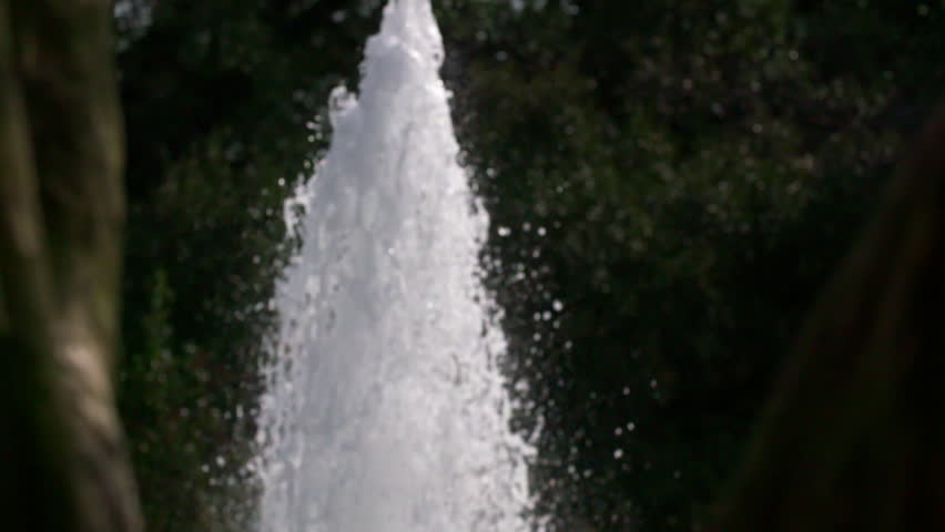Slow Motion Shot Of Water Spraying Upwards At Fountain In Front Of Trees - Los Angeles, California