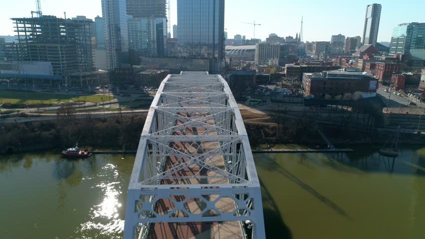 Aerial Shot Of Modern Buildings In City Against Clear Sky, Drone Flying Forward John Seigenthaler Pedestrian Bridge - Nashville, Tennessee Royalty-Free Stock Footage #1102310275