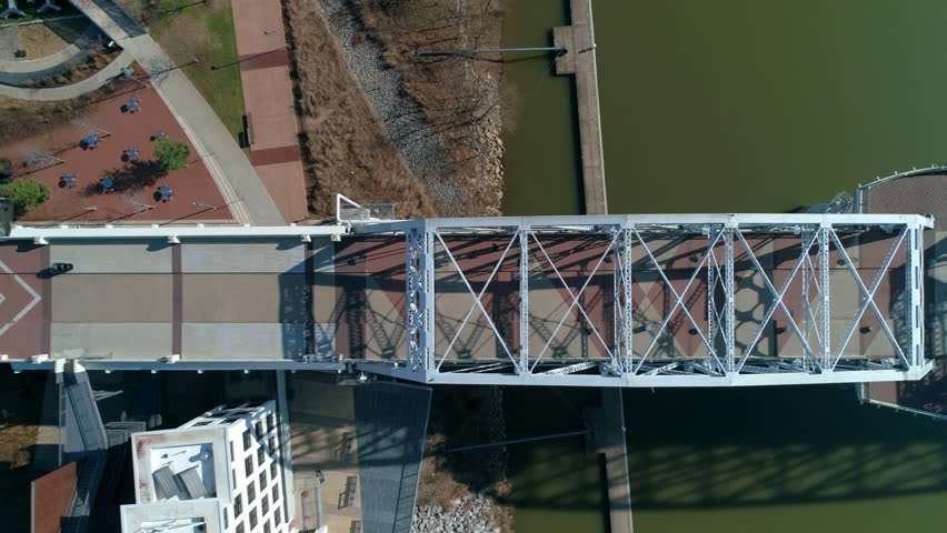 Aerial Top Panning Shot Of John Seigenthaler Pedestrian Bridge On Cumberland River During Sunny Day - Nashville, Tennessee Royalty-Free Stock Footage #1102310279