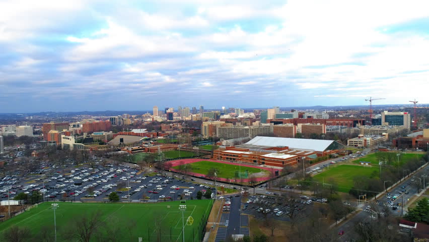 Aerial Backward Shot Of Downtown District With Cars Moving On Roads Under Sky In City - Nashville, Tennessee