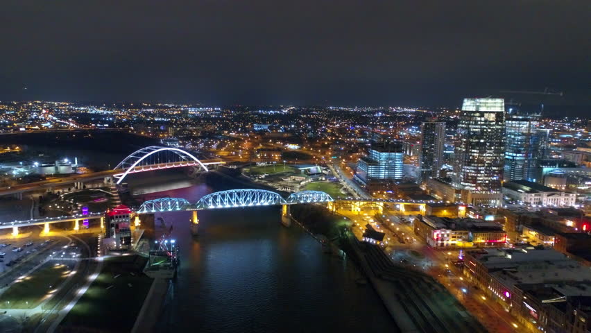 Aerial Shot Of Famous Bridges Amidst Modern City Landscape, Drone Flying Forward Over Cumberland River At Night - Nashville, Tennessee Royalty-Free Stock Footage #1102310463