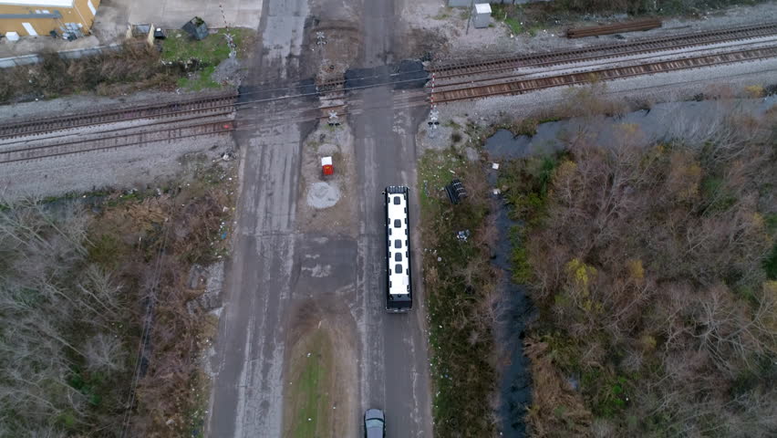 Aerial Forward Shot Of Motorhome Bus Moving Amidst Railroad Tracks Amidst Landscape - New Orleans, Louisiana