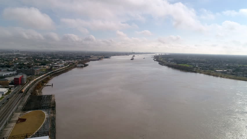 Aerial Shot Of The Mississippi River Amidst City Landscapes, Drone Descending On Sunny Day - New Orleans, Louisiana