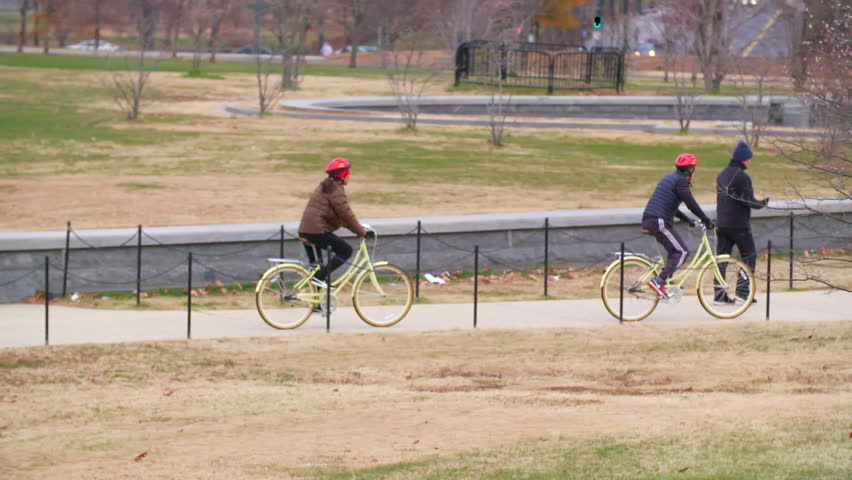 Panning Slow Motion Shot Of Man And Woman Riding Bicycle In Park During Winter - Washington, District of Columbia