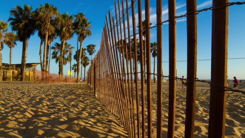 Time Lapse Panning Shot Of Men And Women Seen From Fence At Beach During Sunset - Santa Monica, California