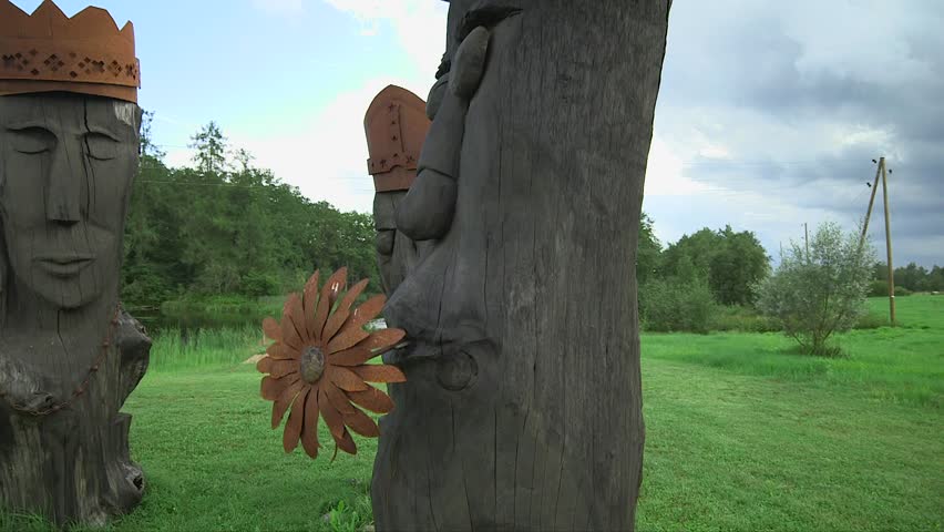 Funny wooden face sculptures. Steadicam shot of comic sculpture faces made of wood and steel.