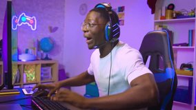 African American man playing action video games on computer stream online broadcast live gaming. Celebrating win. High quality photo
