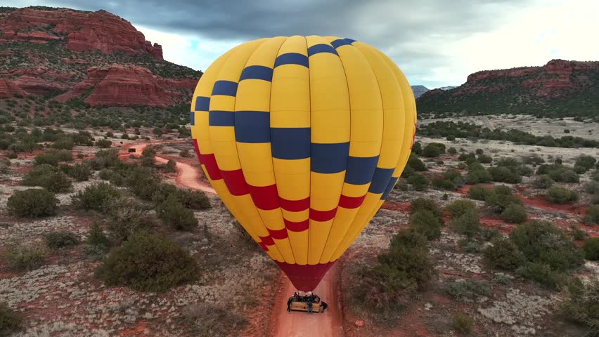 Colorful Hot Air Balloon On The Ground In Sedona, Arizona, USA - aerial pullback
