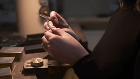 Static close up of a female jeweller making a silver metal mould over a candle to be made into a necklace. Shot on the Isle of Lewis, part of the Outer Hebrides of Scotland. - Powered by Shutterstock - Get 15% off with code: PIKWIZARD15