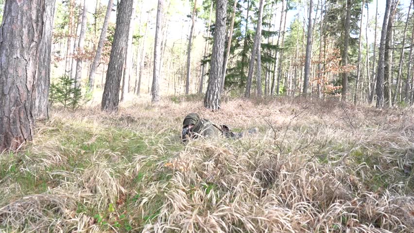 Russian army sniper during military operation.A lone sniper lying in the grass at the edge of the forest. 
Special forces soldier - sniper