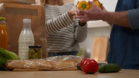 Caucasian middle-aged couple happy family senior adult wife and husband woman and man unpack delivered paper bag package products goods at home kitchen hugging cuddling satisfied with food delivery - Powered by Shutterstock - Get 15% off with code: PIKWIZARD15