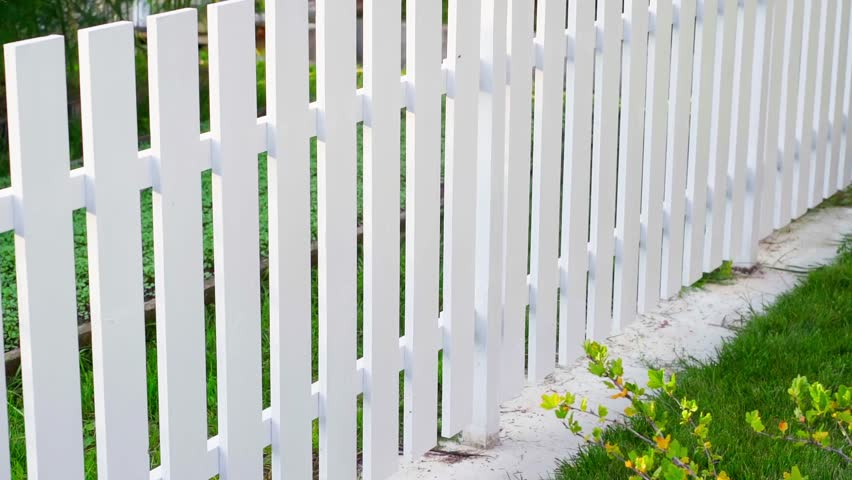 Beautiful smooth white wooden fence made by hand. Summer day, stylish vegetable garden fence, smooth camera movement Royalty-Free Stock Footage #1102317627