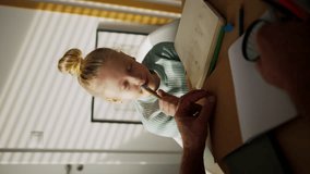 Vertical view of a senior man doing homework with his granddaughter. - Powered by Shutterstock - Get 15% off with code: PIKWIZARD15