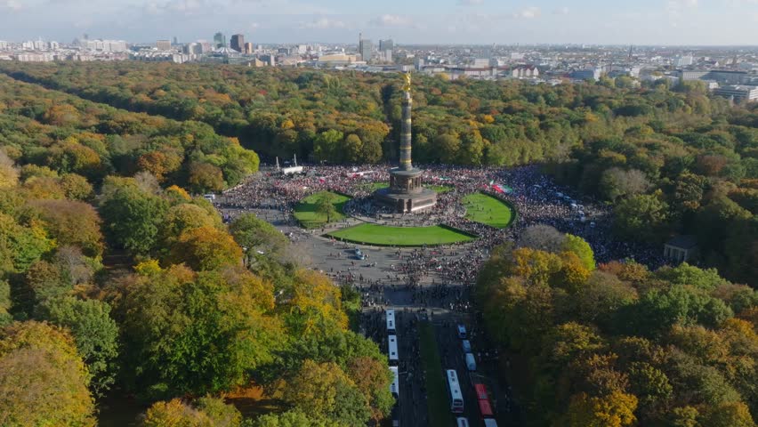 Aerial panoramic view of Autumn Tiergarten park and crowd of protesting people around Victory column of Grosser Stern. Iranian rally to support women right. Berlin, Germany