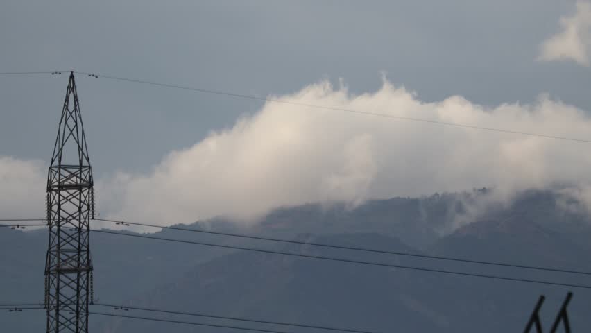 Clouds Emerging From Behind The Hill.