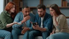 Disappointed sad multiracial people watching sport game streaming on mobile phone upset by lost soccer match sit on couch diverse women men friends football fans looking at cellphone lose bad result - Powered by Shutterstock - Get 15% off with code: PIKWIZARD15