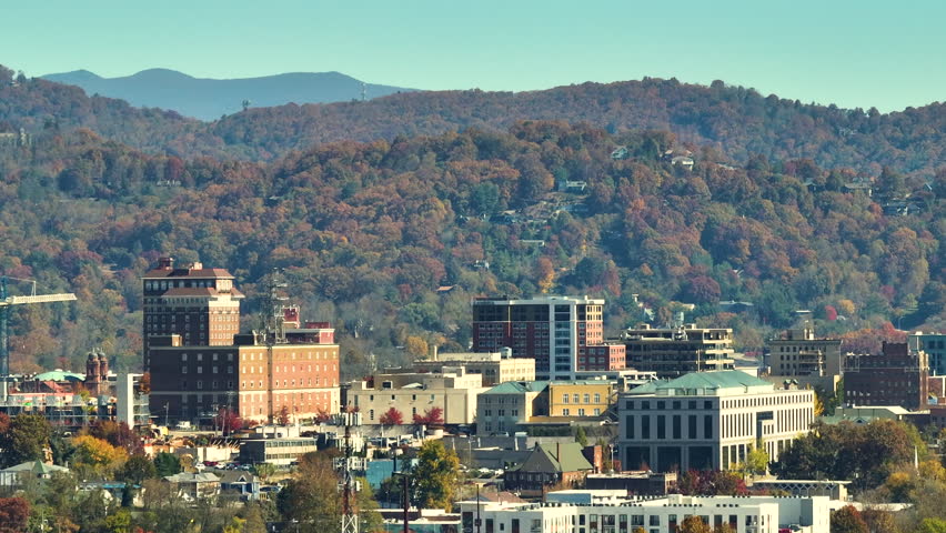Aerial view of Asheville city in North Carolina with high buildings and mountain hills in distance Royalty-Free Stock Footage #1102335203