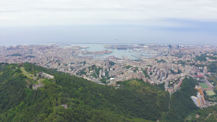 Inscription on video. Genoa, Italy. Central part of the city, aerial view. Ships in the port. Different colors letters appears behind small squares, Aerial View
